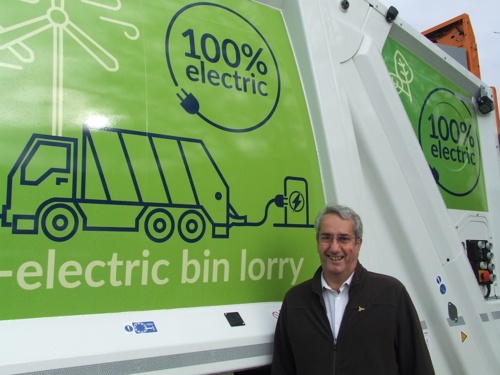 Cllr Brian Milnes standing in front of an electric bin lorry