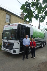 Cllr Brian Milnes and Cllr Rosy Moore with Greater Cambridge Shared Wastes second fully electric bin lorry on a street in Elsworth