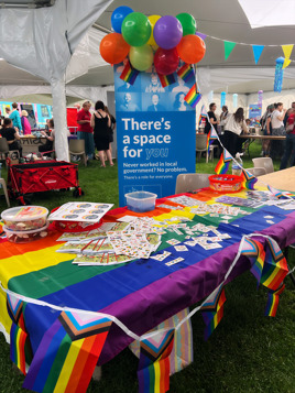 Cambridge Pride stall with Council banner, leaflets and rainbow temporary tattoos