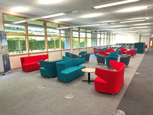 Red and green sofas in a communal work space