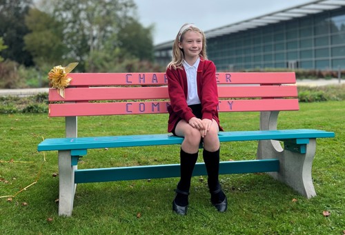 A student from Melbourne sits on a bench she designed
