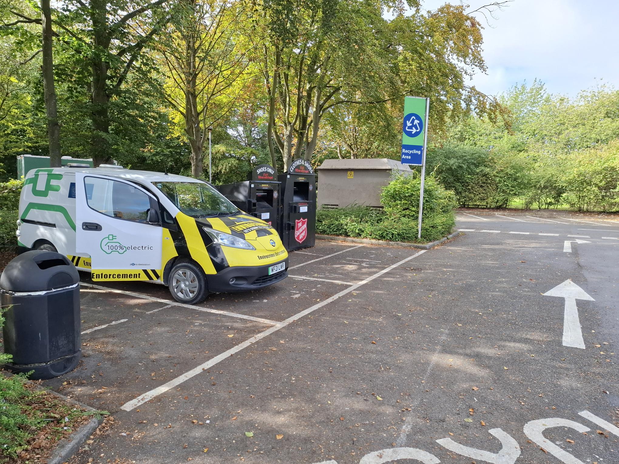 South Cambridgeshire District Council environmental enforcement vehicle parked beside clothing and shoe recycling banks at a recycling area in Fulbourn.